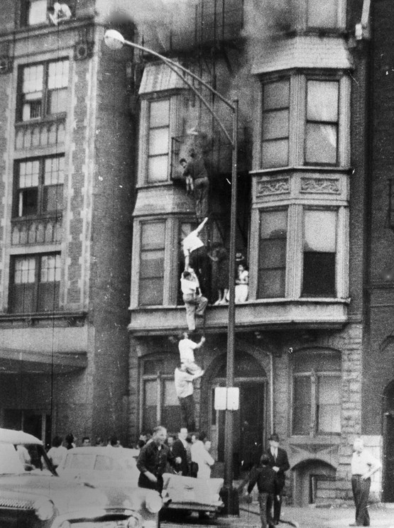 1958_chain_of_people_fleeing_a_fire_descends_a_ladder_fire_escape_as_smoke_pours_from_the_upper_windows_of_the_four-story_building_on_the_north_side_of_chicago_only_one_woman_injured.jpeg