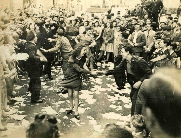 1945. London, Piccadilly. Katonák, rendőrök és civilek táncolva ünneplik a háború befejezését..jpg