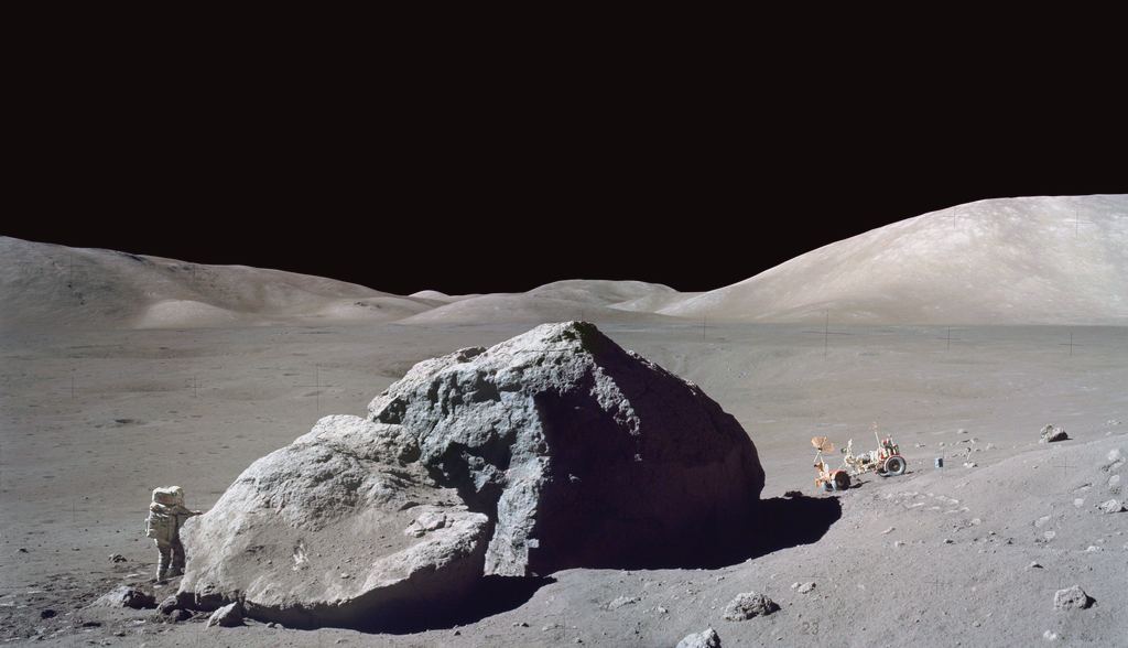 1972_december_13_harrison_h_schmitt_of_the_apollo_17_mission_investigates_a_large_lunar_boulder_with_rover_behind.jpg