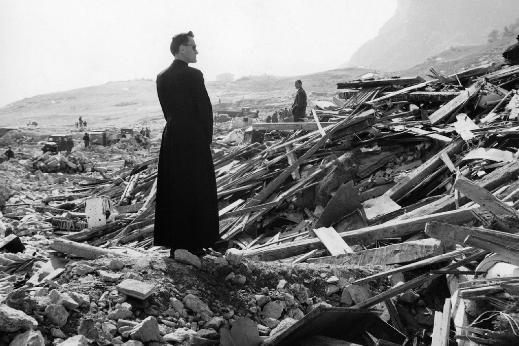 1963_priest_gazes_at_the_remains_of_longarone_after_its_destruction_the_previous_night_the_side_of_a_mountain_collapsed_in_the_vajont_dam_s_lake.jpg