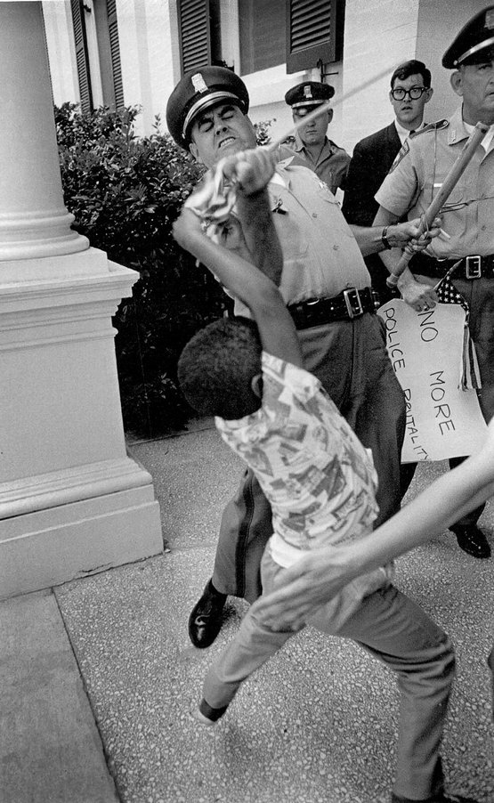 1965_a_policeman_rips_an_american_flag_away_from_a_young_boy_jackson_mississippi.jpg