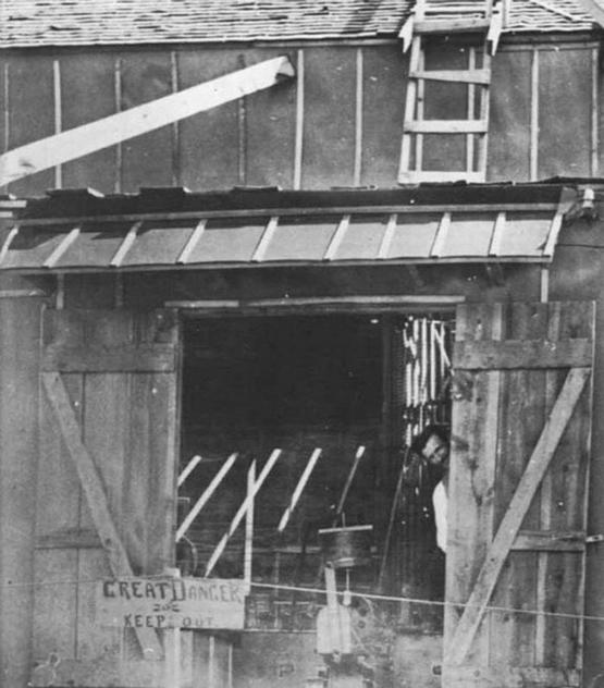 1899_nikola_tesla_looking_out_his_colorado_springs_lab_in_1899_the_sign_reads_great_danger_keep_out.jpg