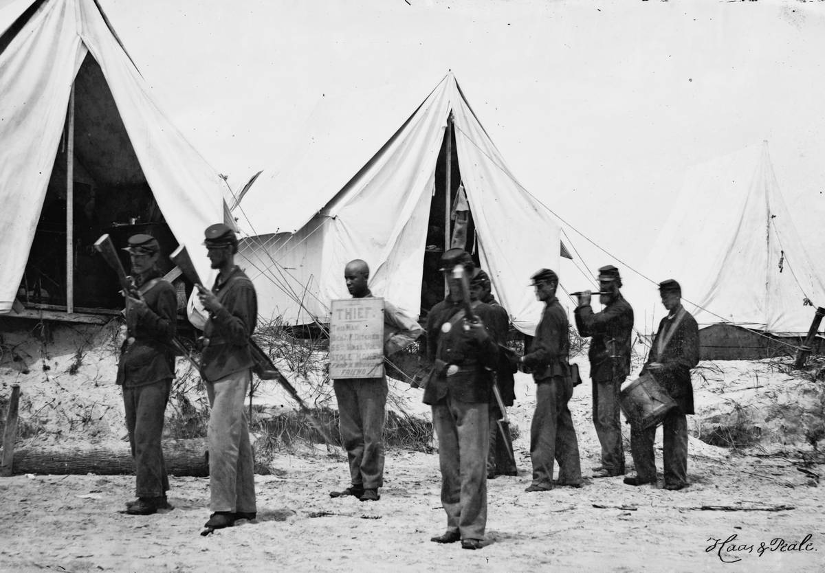 1863. Északi katona, nyakában táblával TOLVAJ! Pénzt lopott sebesült társától..jpg