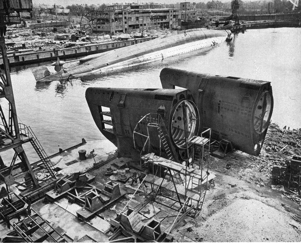 1945_the_admiral_scheer_lays_capsized_in_kiel_near_two_unfinished_german_submarines_of_the_xxi_series_in_kiel_in_may.jpg