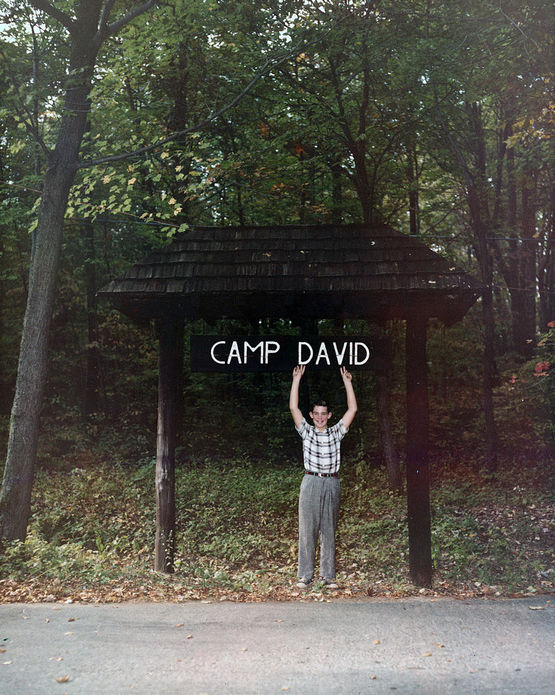 1960_david_eisenhower_grandson_of_president_eisenhower_posing_with_a_sign_at_camp_david_which_was_named_in_his_and_his_great-grandfather_s_honor.jpg