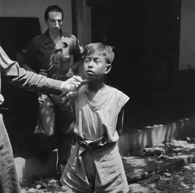 1947_dutch_colonial_soldiers_interrogate_an_indonesian_boy_part_of_a_guerilla_troop_during_the_indonesian_war_of_independence.jpg