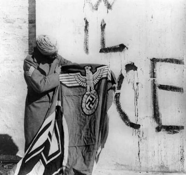 1944_majus_sikh_soldier_of_the_indian_red_eagle_division_showing_a_captured_german_flag_after_taking_over_monte_cassino_italy.jpg