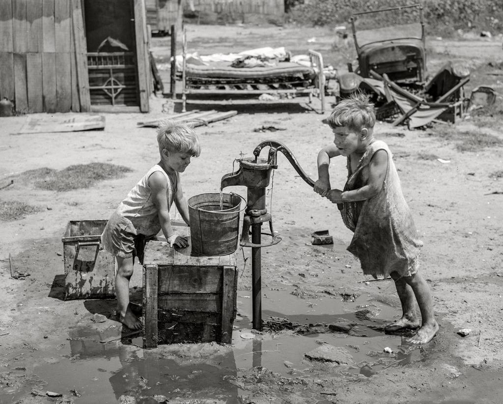 1939_children_of_may_avenue_camp_pumping_water_well_which_supplied_about_a_dozen_families_near_oklahoma_city1.jpg