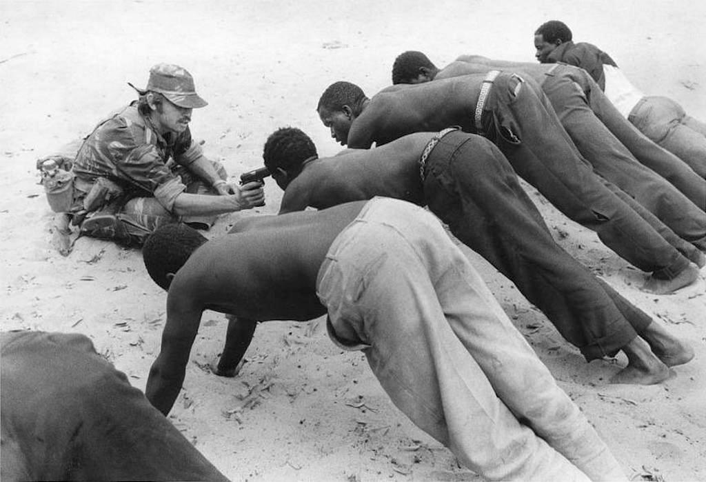1977_rhodesian_soldier_questioning_and_torturing_native_villagers_with_a_pistol_near_the_border_of_botswana.jpg