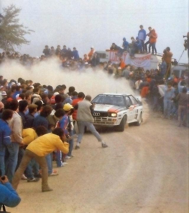 1983_stig_lennart_blomqvist_in_his_group_b_rally_audi_quattro_taking_a_turn_at_high_speed_and_inches_away_from_dozens_of_spectators_during_the_rallye_sanremo.jpg