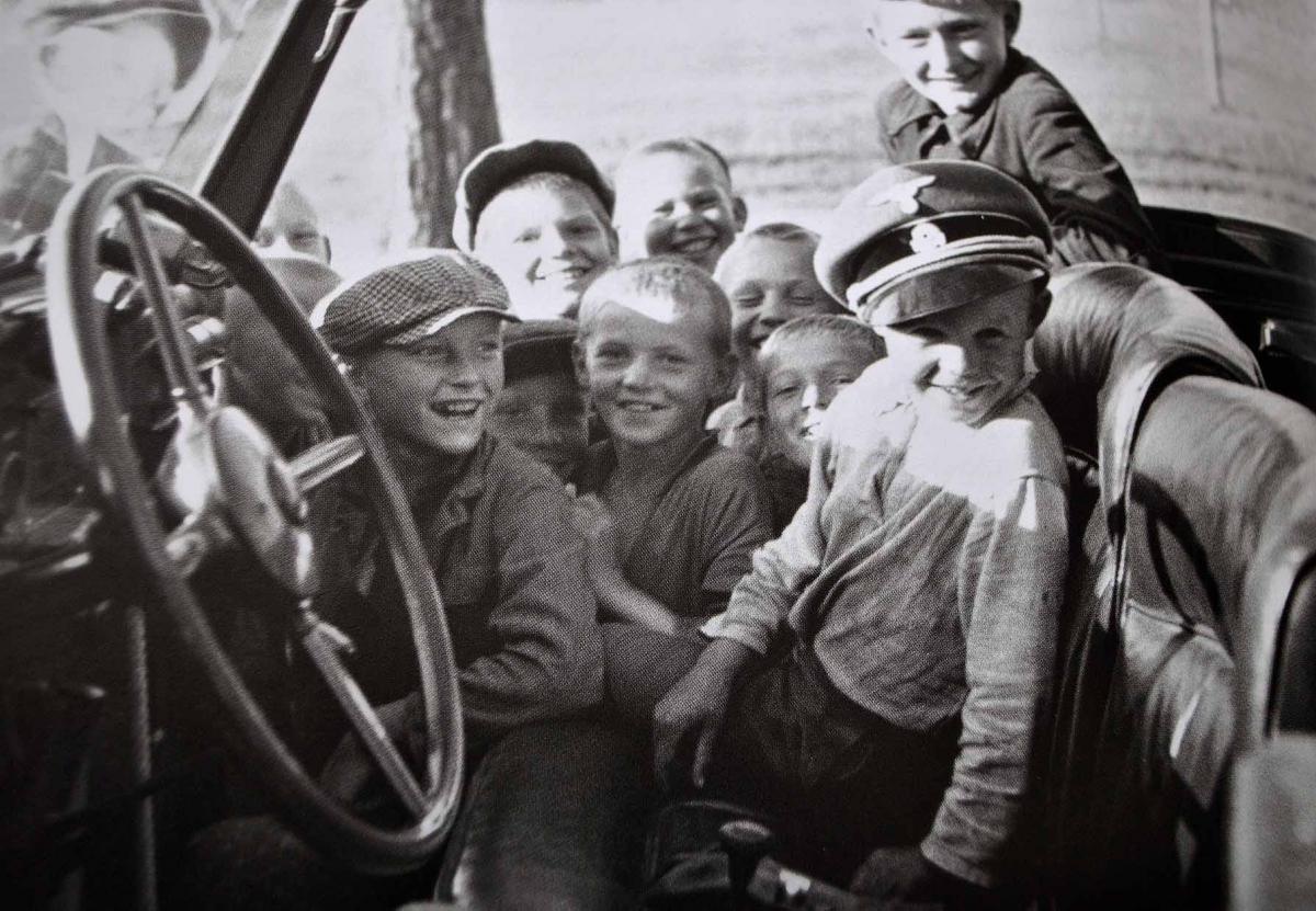 1941. Novinki. Szovjet gyerekek játszanak Himmler sapkájában és autójában..jpg
