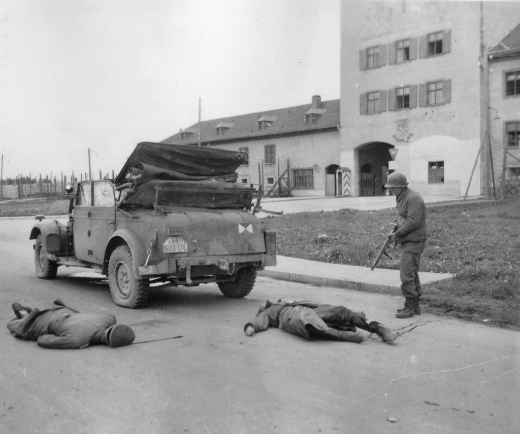 1945_aprilis_29_american_soldier_inspects_the_corpses_of_german_nazi_gen_ernst_fick_and_driver_who_were_delivering_orders_to_kill_all_the_pows_at_murnau_prison.jpg