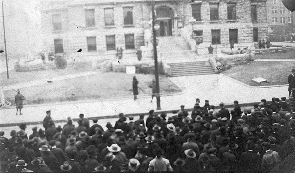 1920_a_white_mob_consisting_of_thousands_of_people_many_of_whom_are_hoping_to_participate_in_or_witness_a_lynching_stands_outside_the_courthouse_lexington_kentucky.png