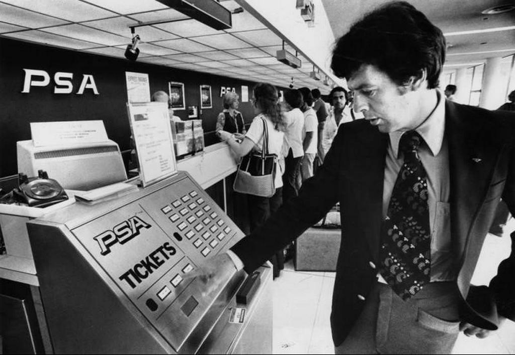 1978_pacific_southwest_airlines_assistant_manager_at_los_angeles_international_airport_demonstrates_the_airlines_newly_installed_automated_ticket-vending_machine_called_fasticket.jpg