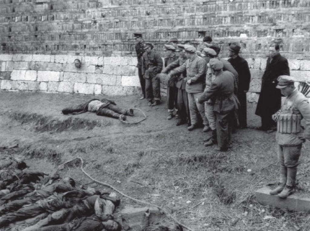 1948_chinese_nationalist_officers_examine_the_bodies_of_communist_raiders_following_a_failed_attack_near_shanghai.jpg