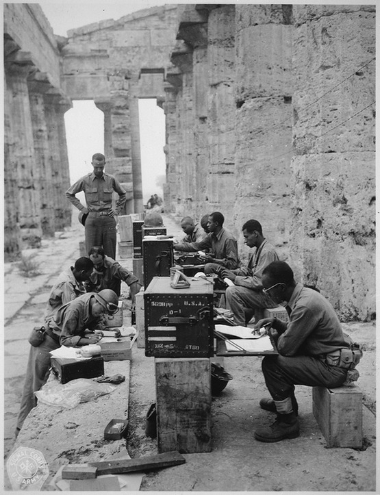 1943_a_company_of_african_american_soldiers_has_set_up_its_office_between_the_doric_columns_of_the_ancient_greek_second_temple_of_hera_paestum_italy.jpg