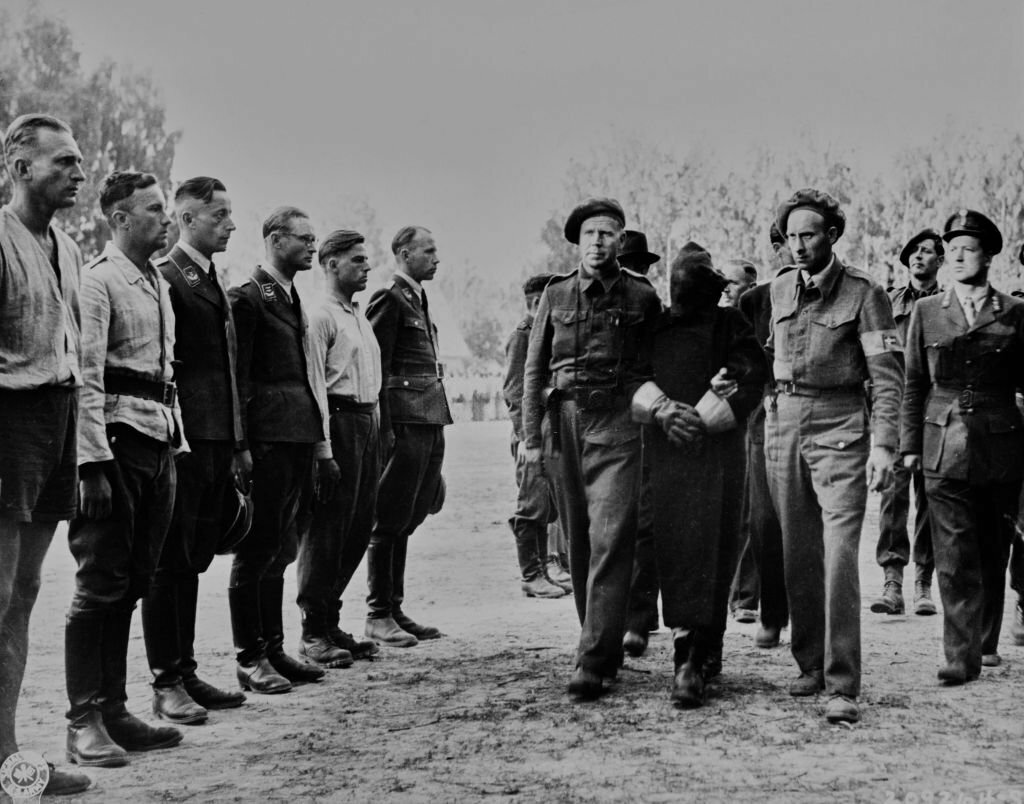 1945_a_secret_informer_is_escorted_by_allied_intelligence_officers_he_walks_past_a_line_of_german_soldiers_in_the_search_for_high-ranking_nazi_officials_hiding_among_regular_troops_oslo.jpg