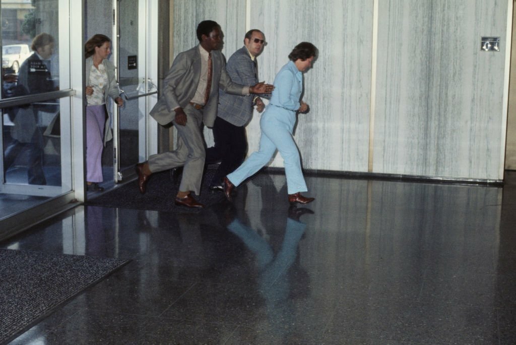 1975_sara_moore_is_brought_into_the_federal_building_in_san_francisco_california_for_arraignment_following_her_assassination_attempt_on_president_gerald_ford.jpg
