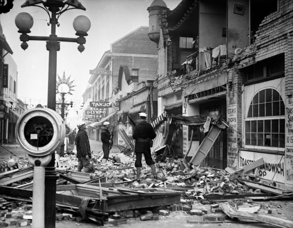 1933_earthquake_aftermath_men_sailors_standing_in_rubble_of_destroyed_shops_restaurants_long_beach_ca_usa.jpg