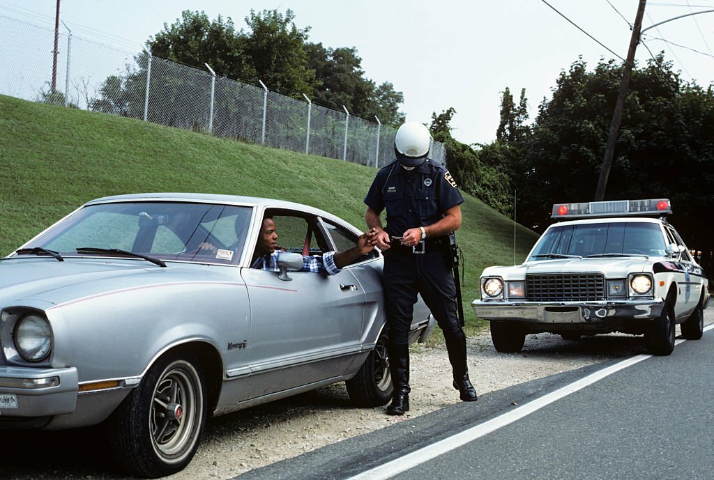 1970s_police_officer_checking_drivers_license.jpg