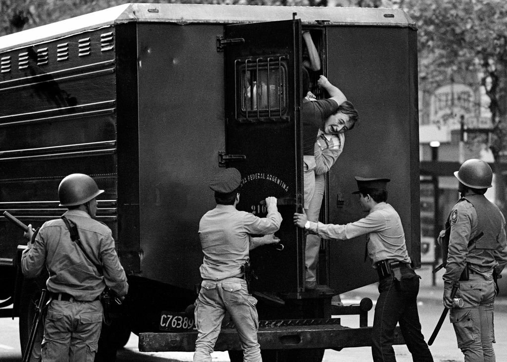 1982_buenos_aires_arrested_citizens_being_loaded_onto_a_police_van_by_special_forces_of_the_federal_police_during_a_cgt_workers_union_march_protesting_against_the_military_dictatorship.jpg