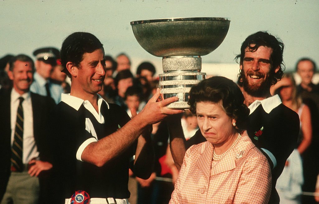 1984_queen_elizabeth_ii_makes_a_funny_face_as_prince_charles_holds_a_trophy_above_her_head_following_a_polo_match_at_windsor.jpg