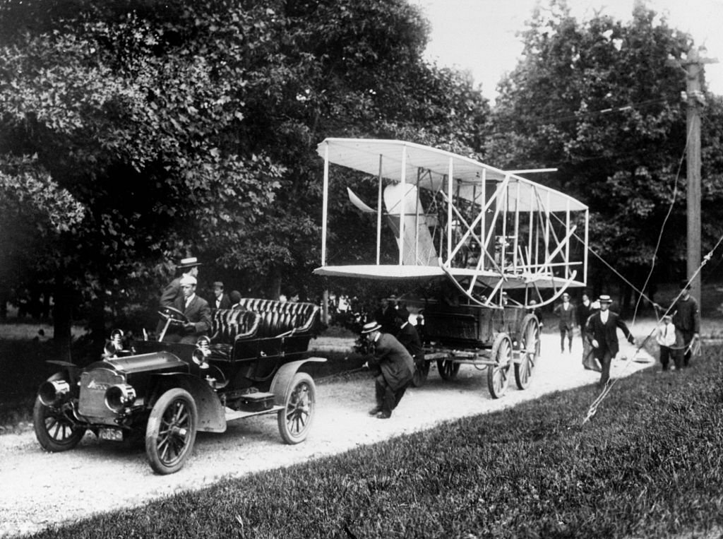 1908_wright_brothers_hauling_plane_with_car_to_fort_myer.jpg
