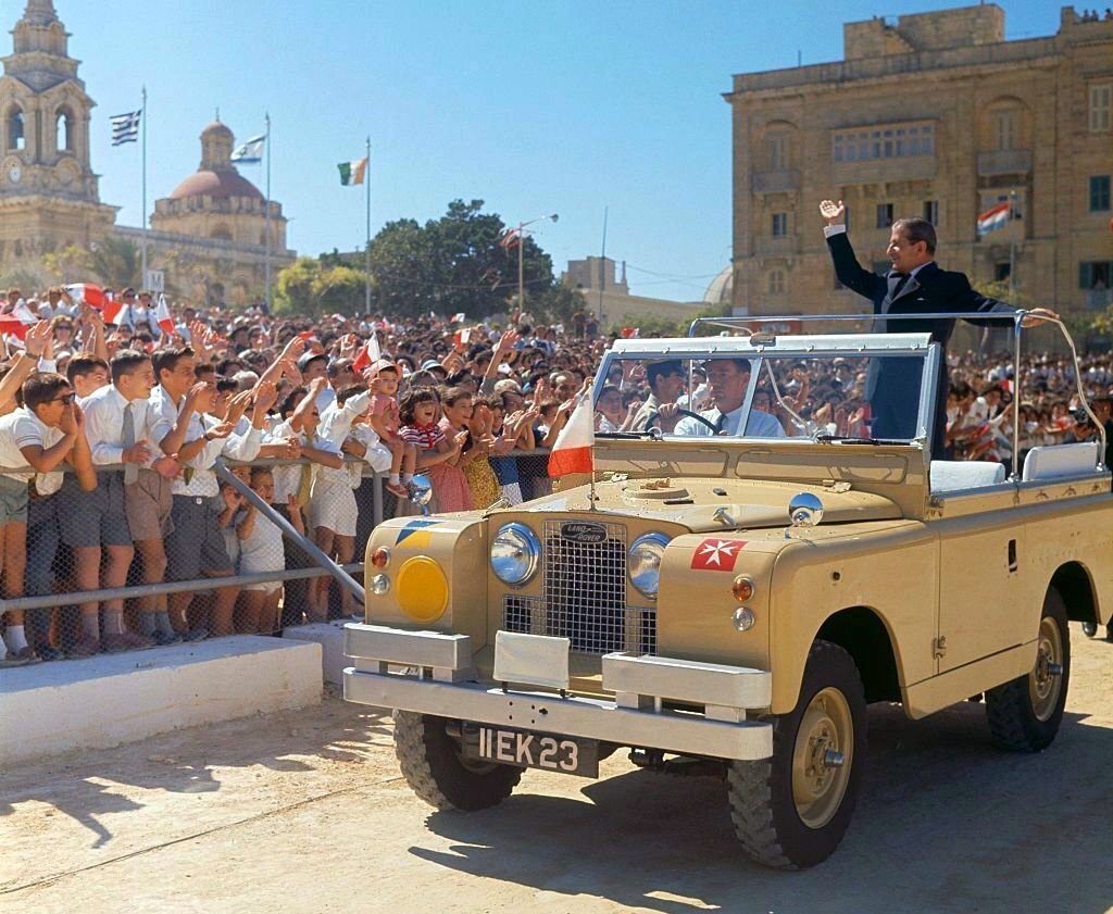 1964_prime_minister_of_malta_giorgio_borg_olivier_1911-1980_waves_from_the_rear_platform_of_an_open_top_land_rover_to_crowds_of_people_lining_the_streets_during_independence_day_celebrations_in_malta_cr.jpg