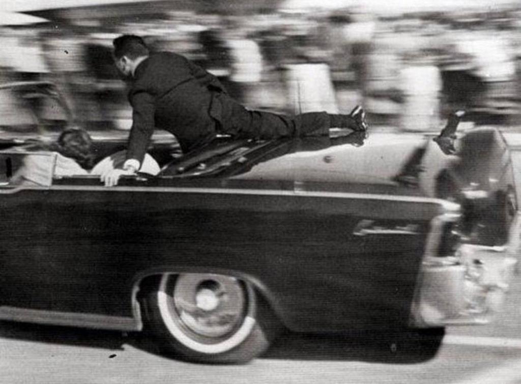 1963_secret_service_agent_clint_hill_jumps_aboard_the_limousine_to_act_as_a_protective_shield_for_jfk.jpeg