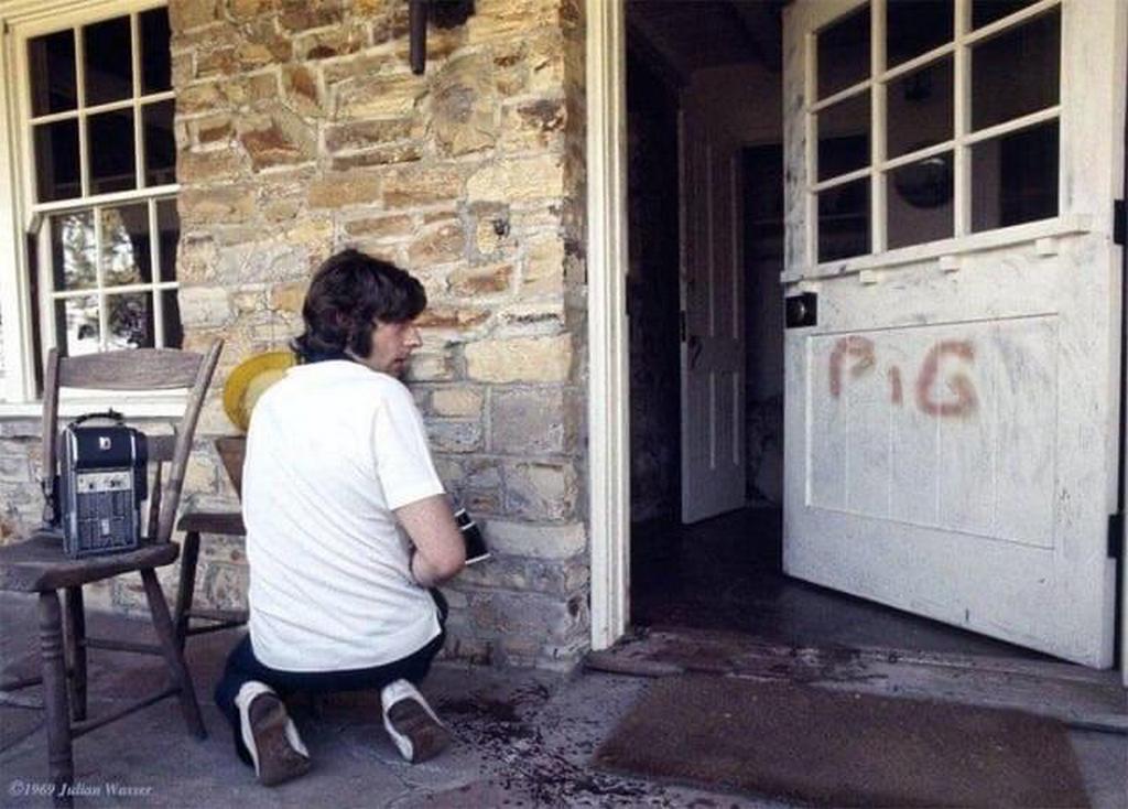 1969_roman_polanski_kneeling_at_his_door_where_pig_is_written_in_his_wife_s_blood_sharon_tate_after_the_manson_family_murders.jpeg