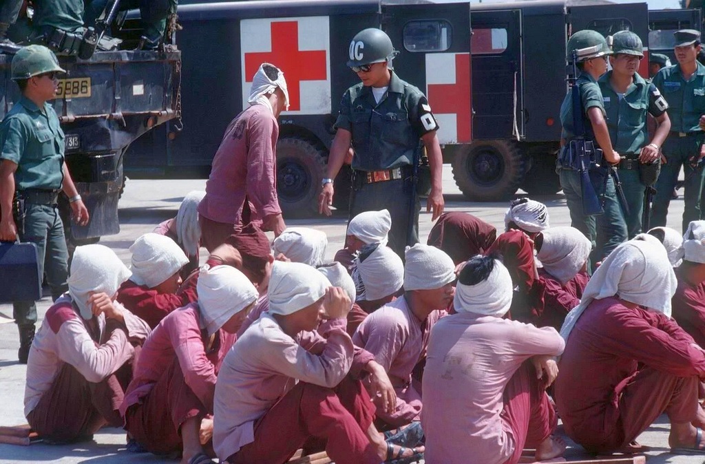 1973_viet_cong_pows_sit_on_the_ramp_at_tan_son_nhut_air_base_under_the_watchful_eyes_of_south_vietnamese_military_police.jpg