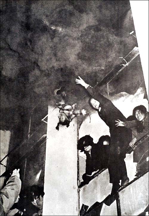 1972. Szöul, Dél-Korea. Egy hatéves kislányt dobnak ki az égő Civic Hall épületéből. A tűzben hatvanan haltak meg, a kislány megmenekült, a lent álló tűzoltók elkapták..jpg