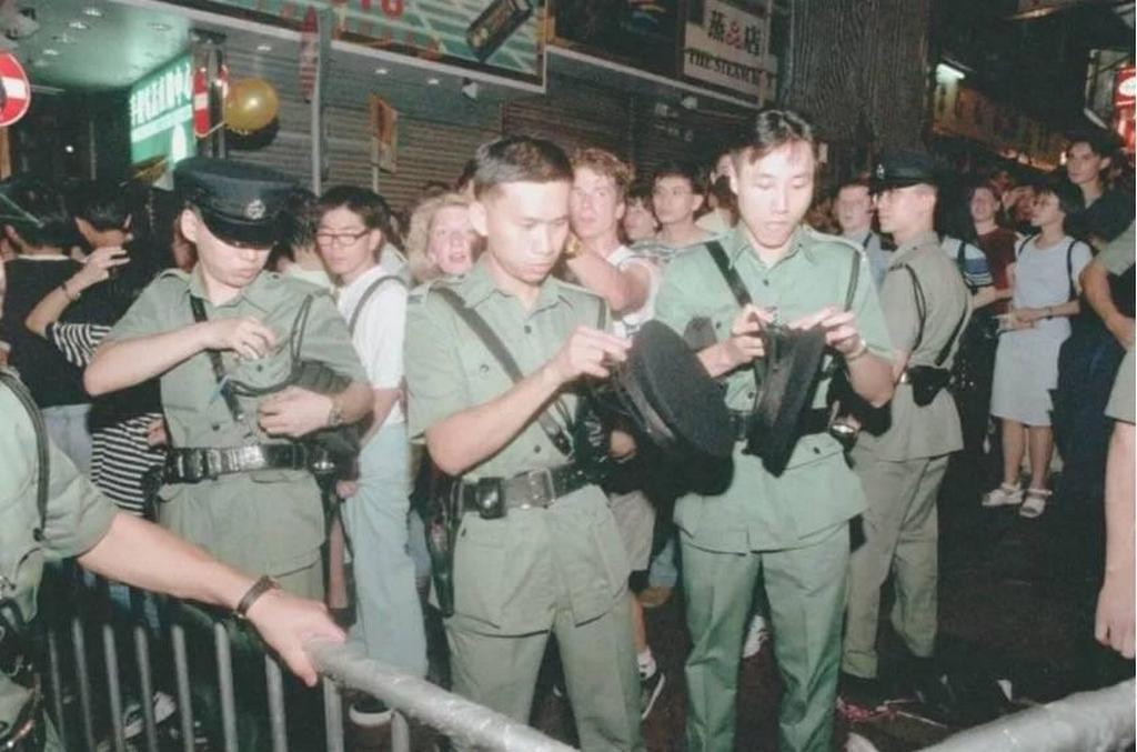 1997_hong_kong_police_officers_change_cap_badges_at_the_stroke_of_midnight_following_the_handover_of_sovereignty_to_china.jpeg