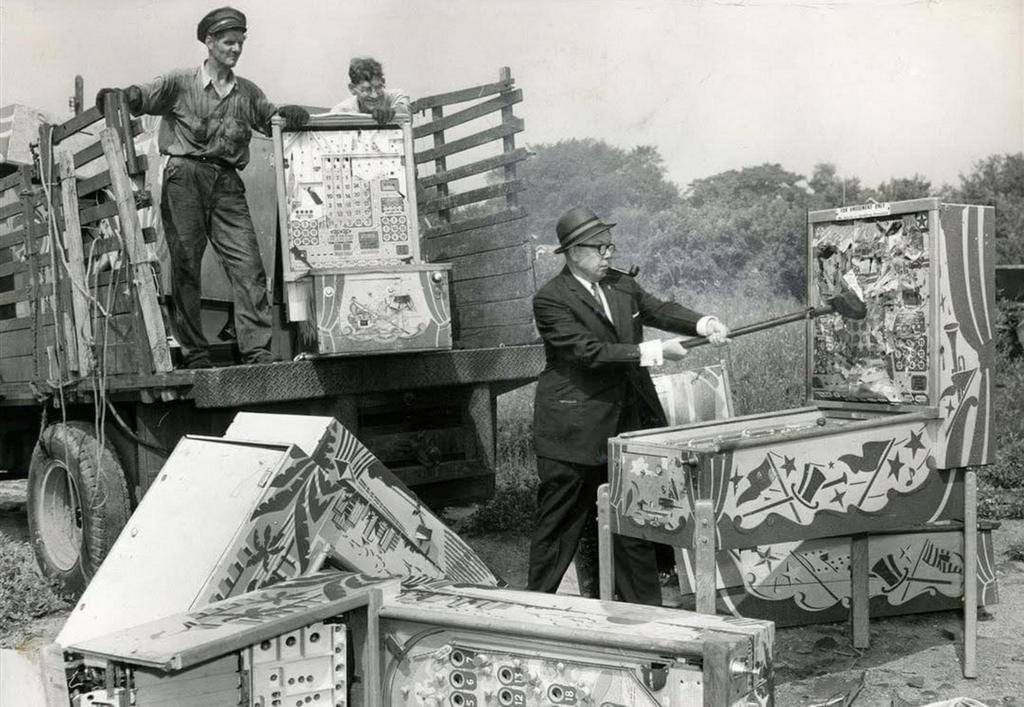 1960_toledo_police_chief_and_a_sledgehammer_to_raze_a_pinball_machine.jpeg