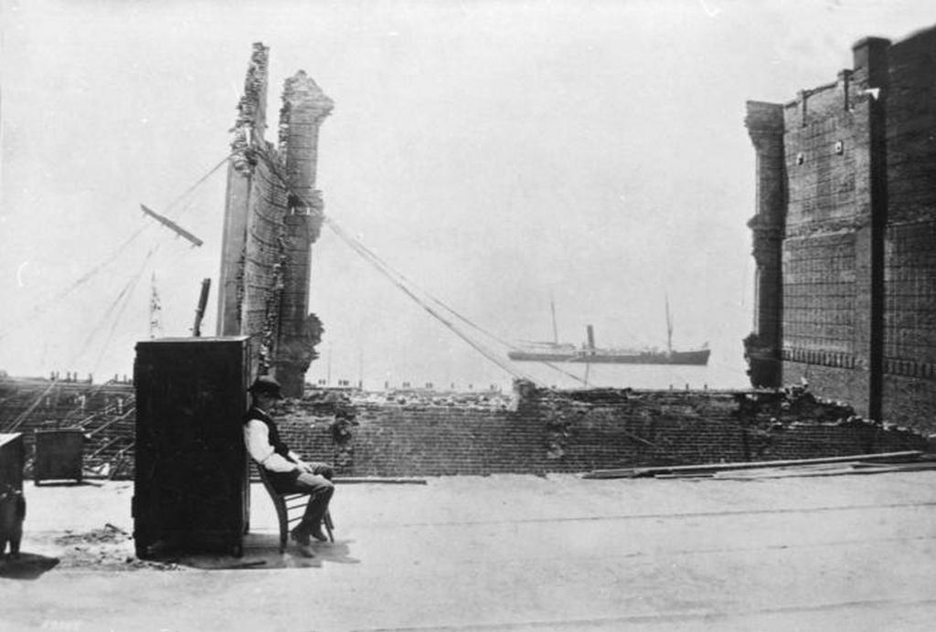 1889_egy_seattle-i_bank_biztonsagi_ore_a_pusztito_foldrenges_utan_az_epulet_romjai_kozt_megmaradt_pancelszekrenyt_orzi.jpeg