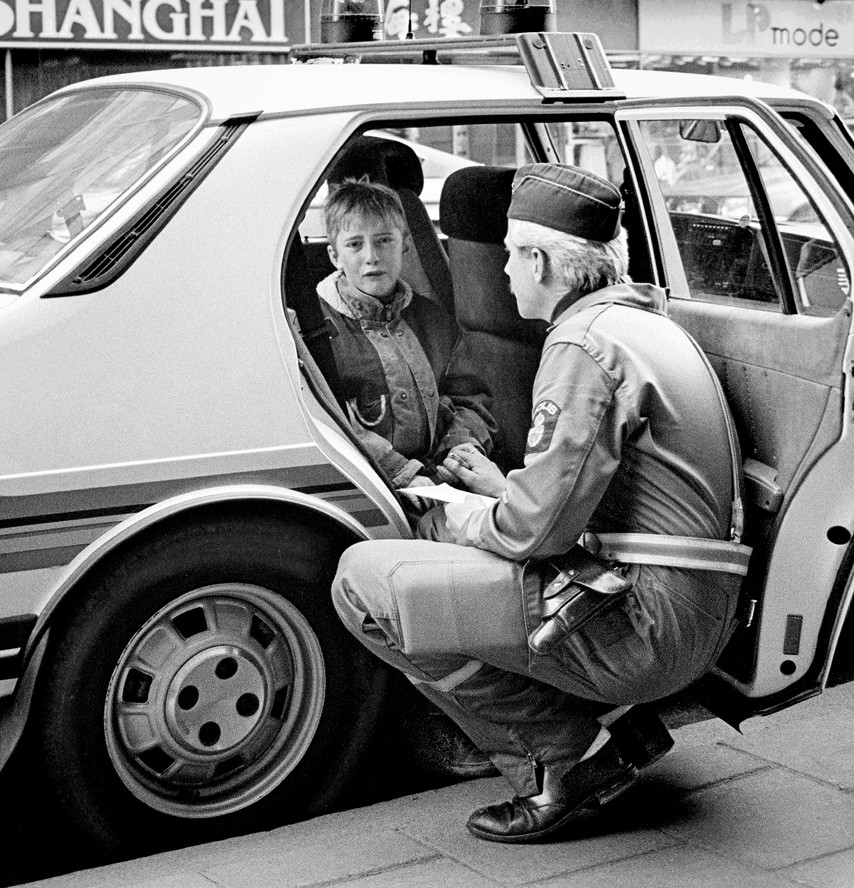 1986. Svéd rendőr vígasztalja a randőrautóban síró gyereket, aki belesetet okozott gördeszkájával..jpg