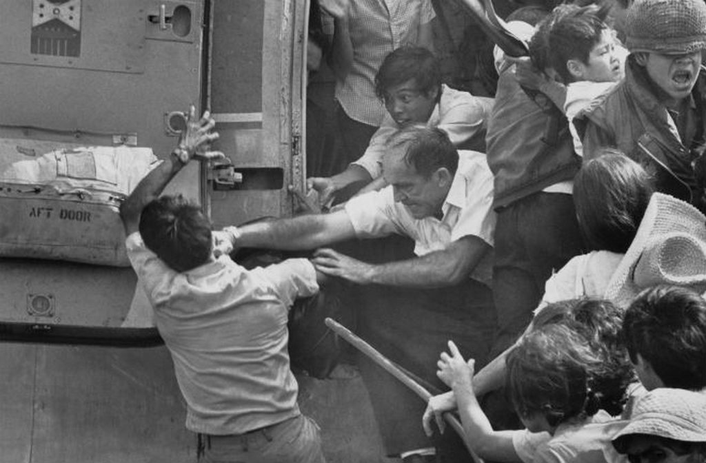 1975_aprilis_saigon_az_eszaki_invazio_miatt_evakualas_alatt_allo_varos_usa_nagykovetsegen_egy_amerikai_ut_arcul_egy_masik_menekulot_hogy_ne_ferjen_fel_a_helikopterre.jpg