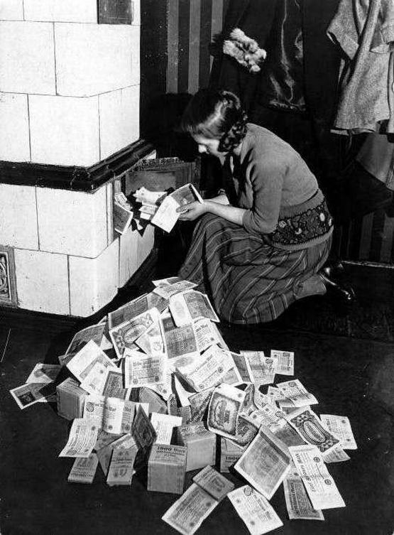 1922_german_woman_burning_tons_of_legal_paper_money_during_the_hyperinflation_of_german_currency.jpeg