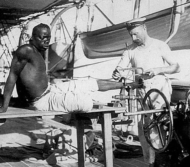 1890 körül. Brit tengerész vágja le egy rabszolga bilincseit..jpg