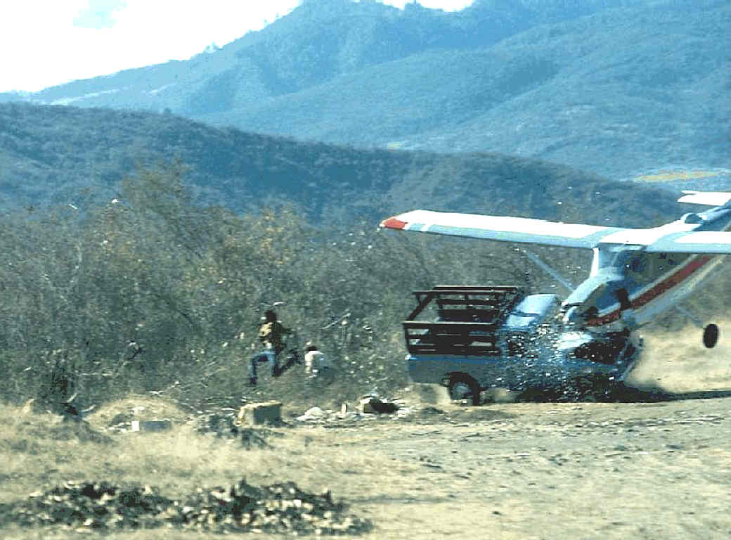 1976. Az erős keresztszél miatt a leszálló kisrepülő a pálya szélén álló kisteherautónak ütközik. Senki sem sérült súlyosan. Sanarate, Guatemala..jpg