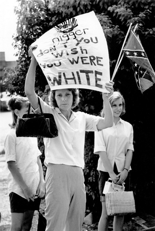 1965. A feketék egyik civil jogi felvonulása mentén lányaival megjelent ellentüntető asszony. A tábla felirata Nigger ne akarj fehér lenni. Bogalusa, Louisiana..jpg