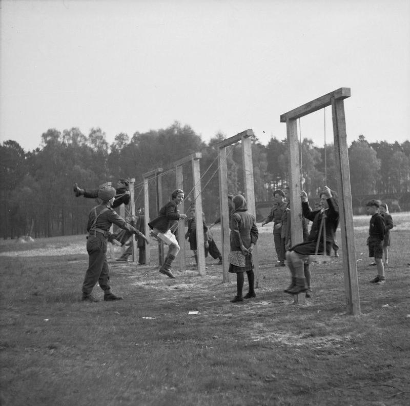 1945. Április 15. Belsen-i koncentrációs tábor közelében kiszabadított gyerekekkel játszanak brit katonák..jpg
