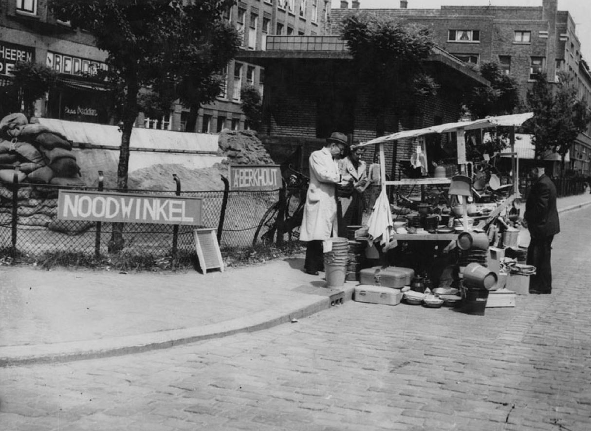 1940. Német bombázás után rotterdami kereskedő a boltja romjai közelében árusít..jpg