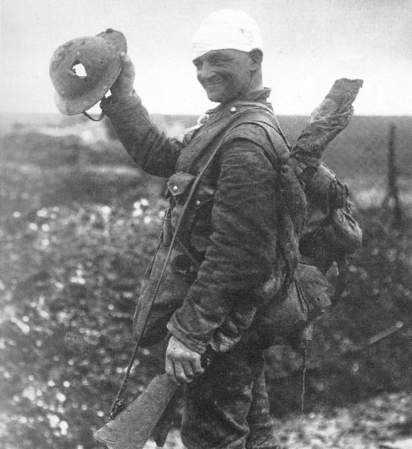 1918. Német katona mutatja a sisakját, amely bár kilyukadt, de megvédte a halálos fejlövéstől..jpg