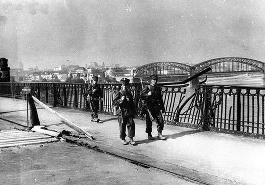 Lengyel katonák Varsóban egy bombázásban sérült hídkorlát mellett.