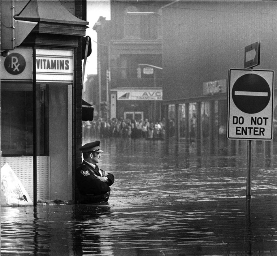 40_amazing_historical_pictures_police_officer_guarding_a_pharmacy_in_high-flood_waters_ontario_1974.jpg