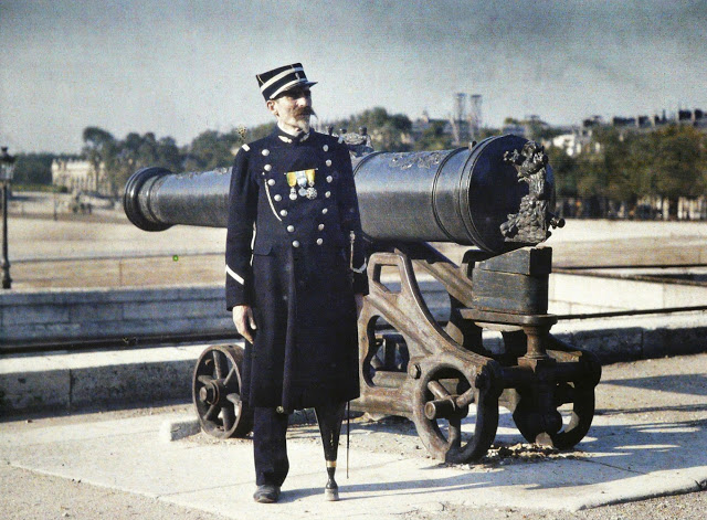 a_soldier_in_uniform_with_three_medals_stands_next_to_a_cannon_in_paris_in_1918_his_left_leg_has_been_replaced_by_an_artificial_limb_r_schultz_collection_the_image_works.jpg