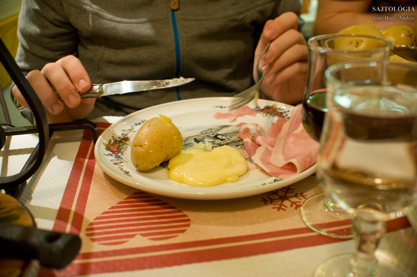 A tányéron: főtt krumpli, felvágott, olvadt Raclette sajt.