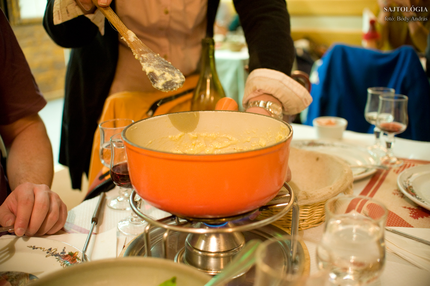 Fondue utolsó fázis: a háziasszony tojást és bagettet habar a sajtos keverékbe.