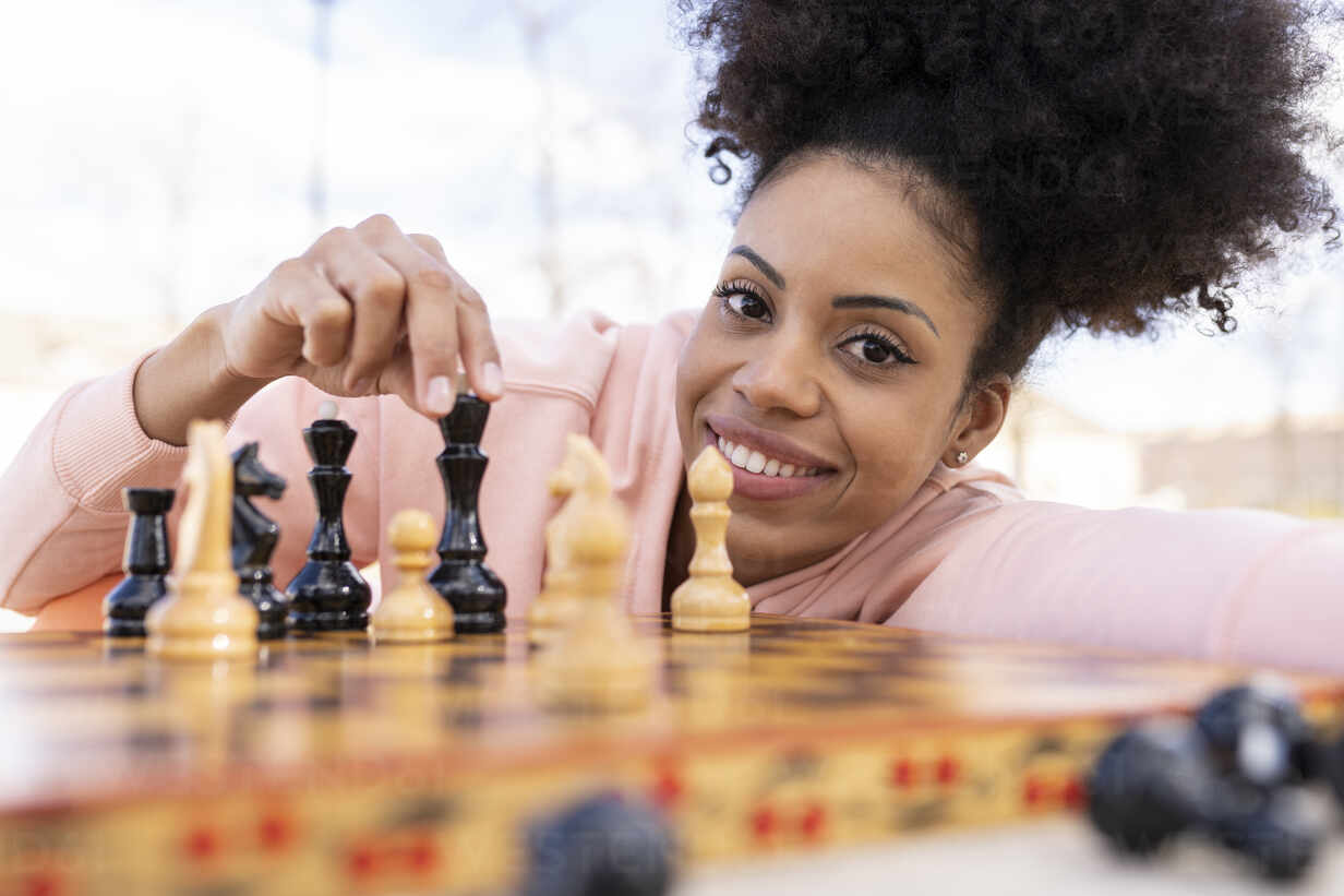 smiling-woman-playing-chess-while-leaning-on-table-jccmf01790_1.jpg